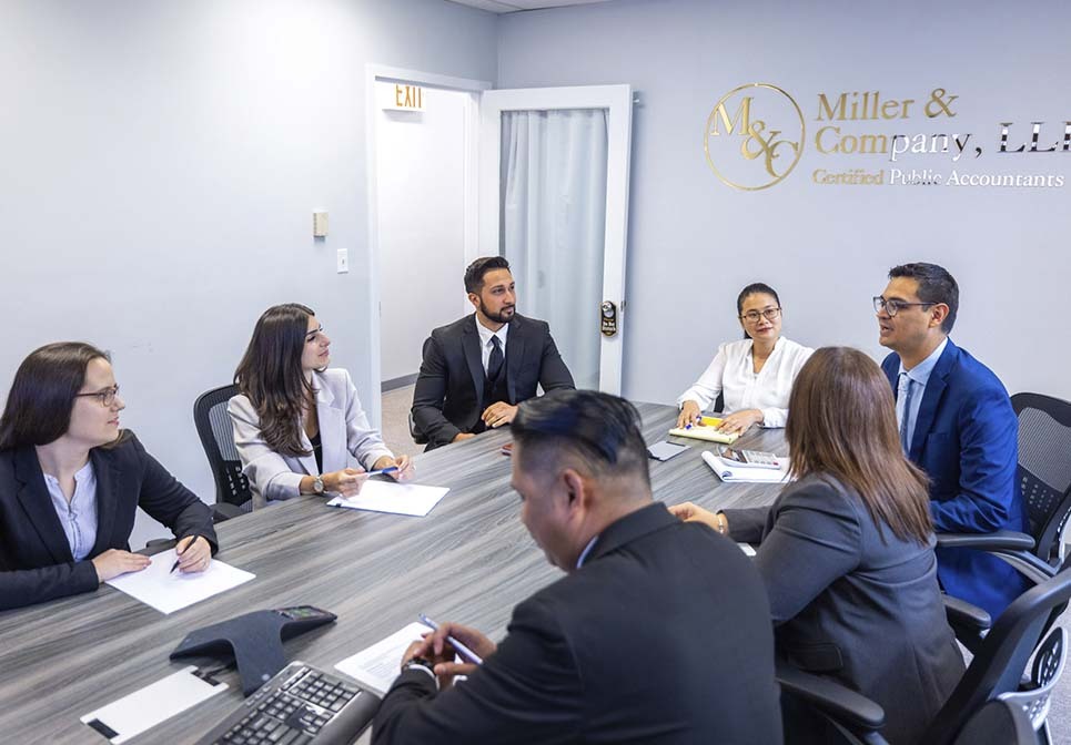 Miller & Company LLP accounting professionals meeting to review complex tax compliance matters.